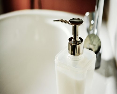 Person properly washing hands with soap at a clean sink